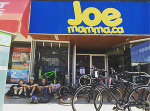 Kids sitting with their bikes in front of store